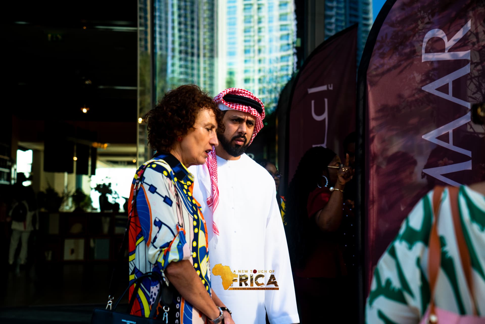 An ANTOA guest in vibrant print speaking with the Emirati host during the Dubai city tour